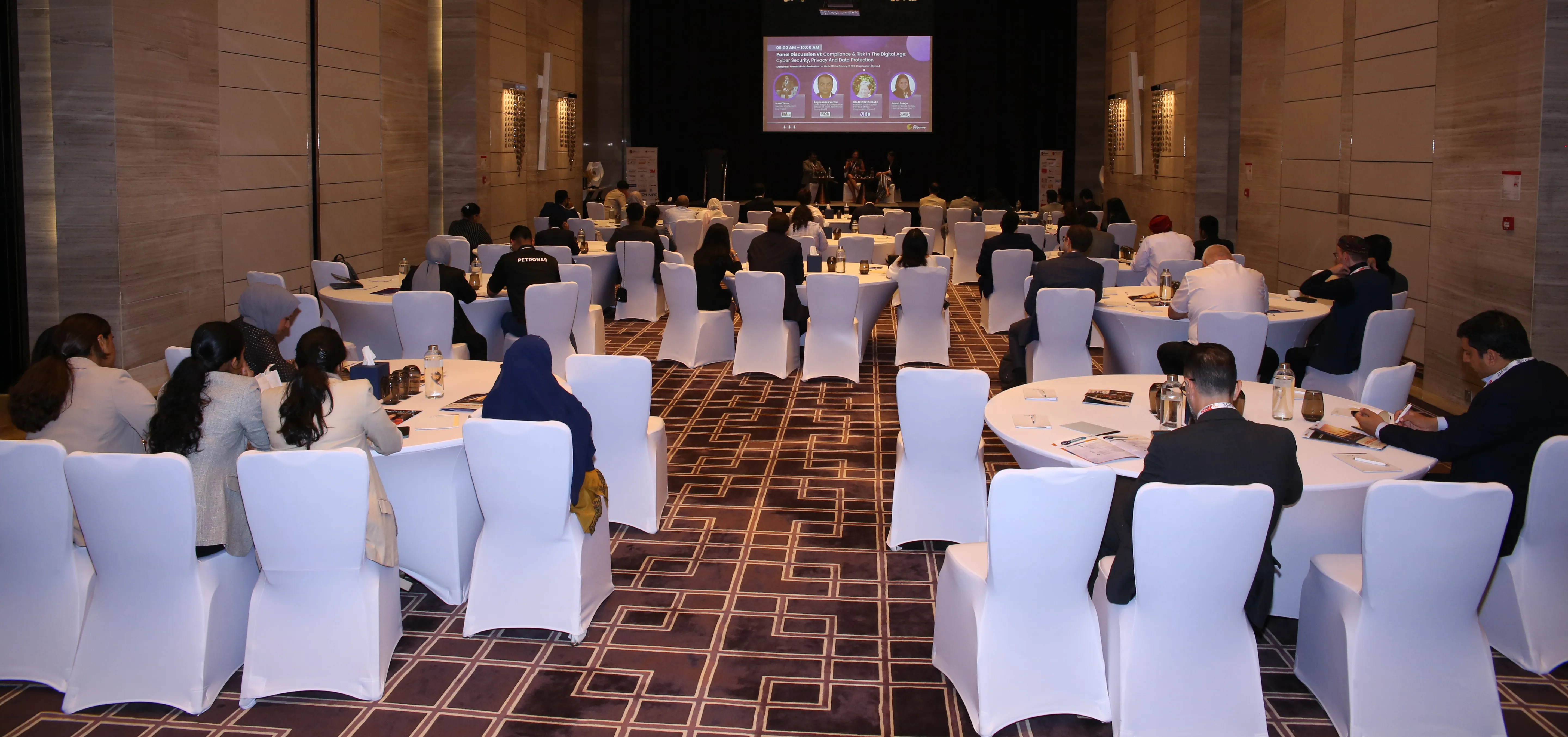 Banquet room set up with round tables ahead of a conference dinner