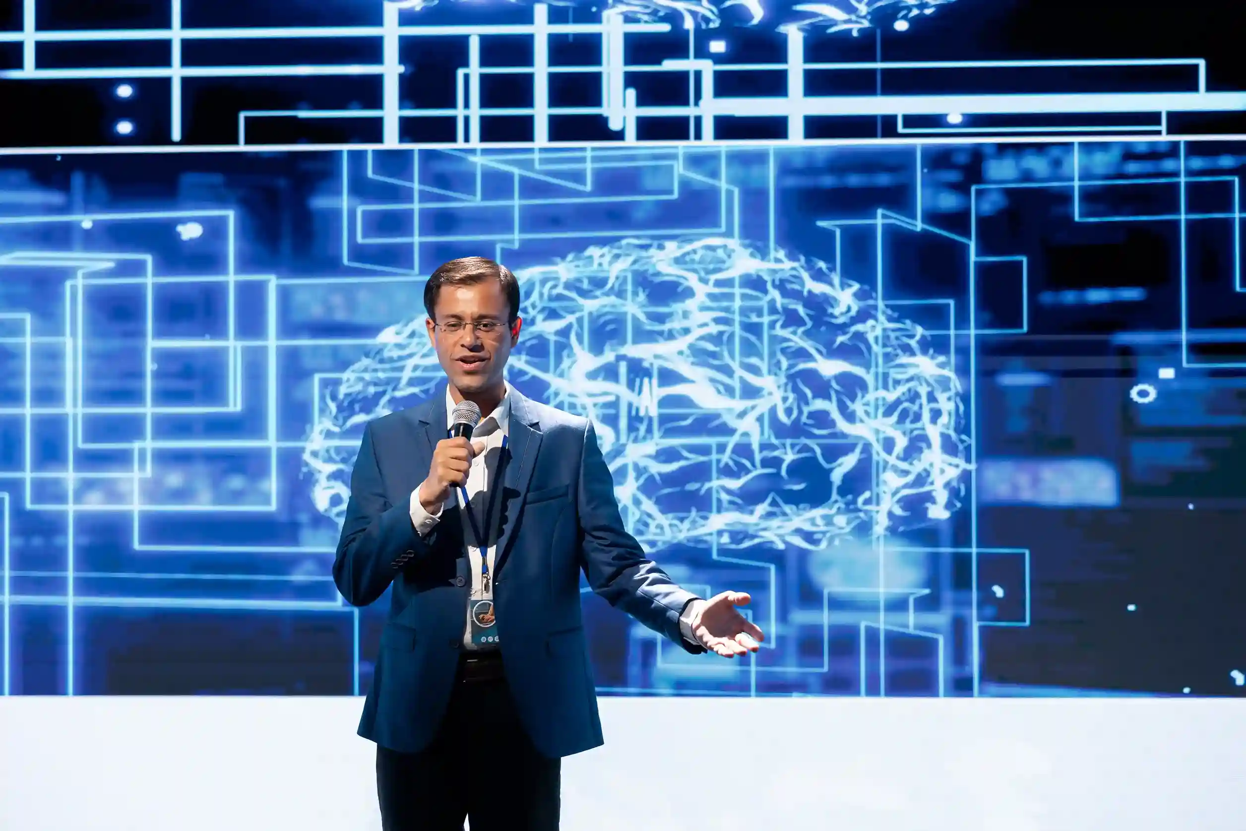 Keynote speaker presenting on stage with AI brain background
