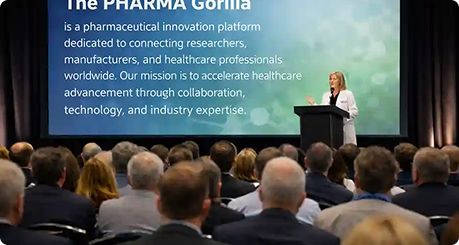 Speaker presenting to a conference audience with The Pharma Gorilla mission statement on screen